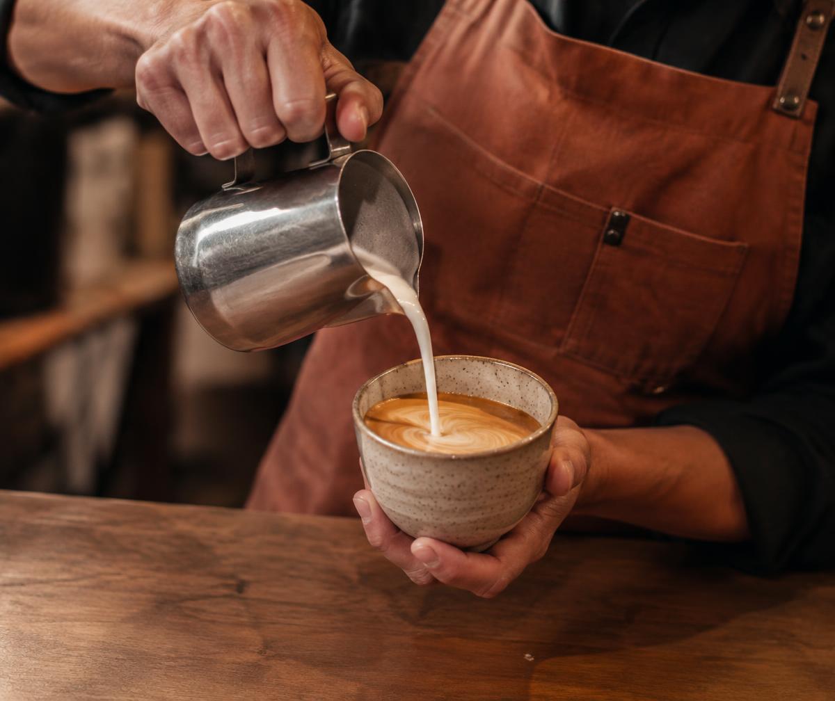 Barista pouring steamed milk